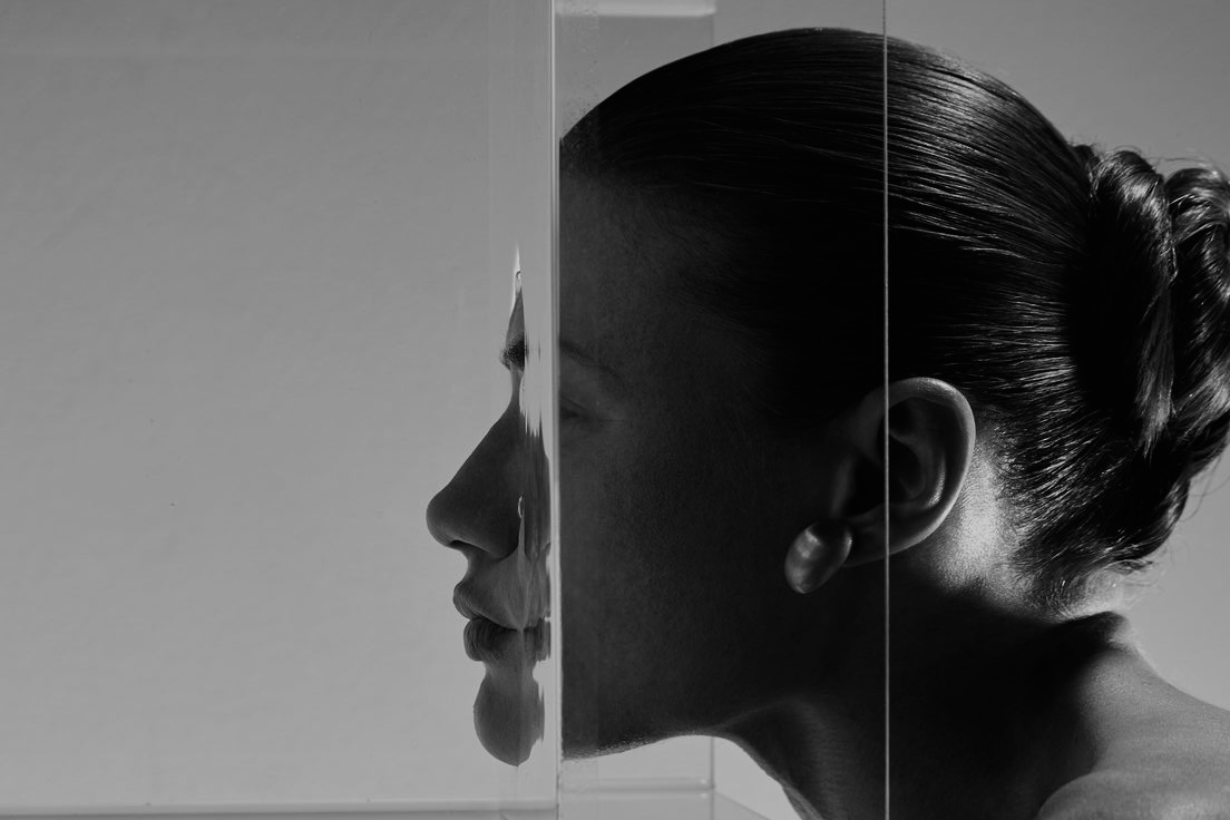 Zwart-wit portret van een vrouw bij een spiegel